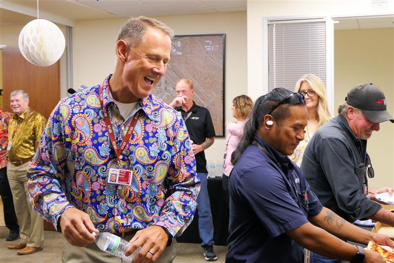 Airport staff and guests laughing together at a community event