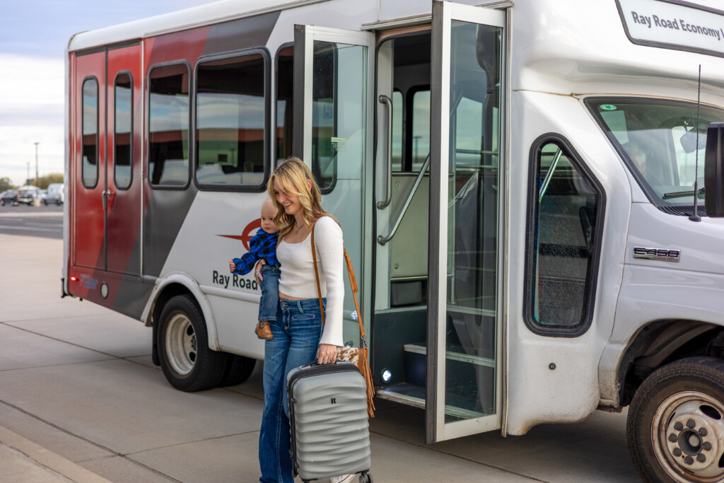 Traveler with luggage boarding the Economy Lot shuttle bus