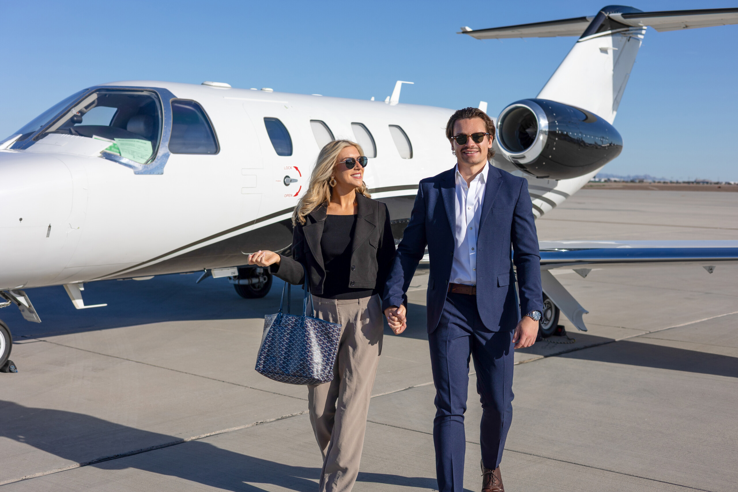 Couple walking beside a private jet on the ramp
