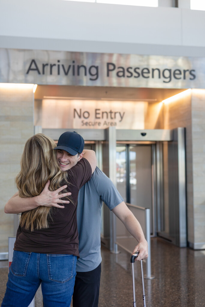 Two people hugging at the arrivals exit