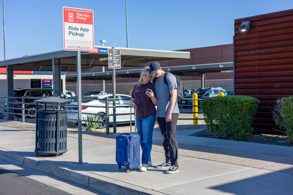 Couple with luggage at the rideshare pickup zone
