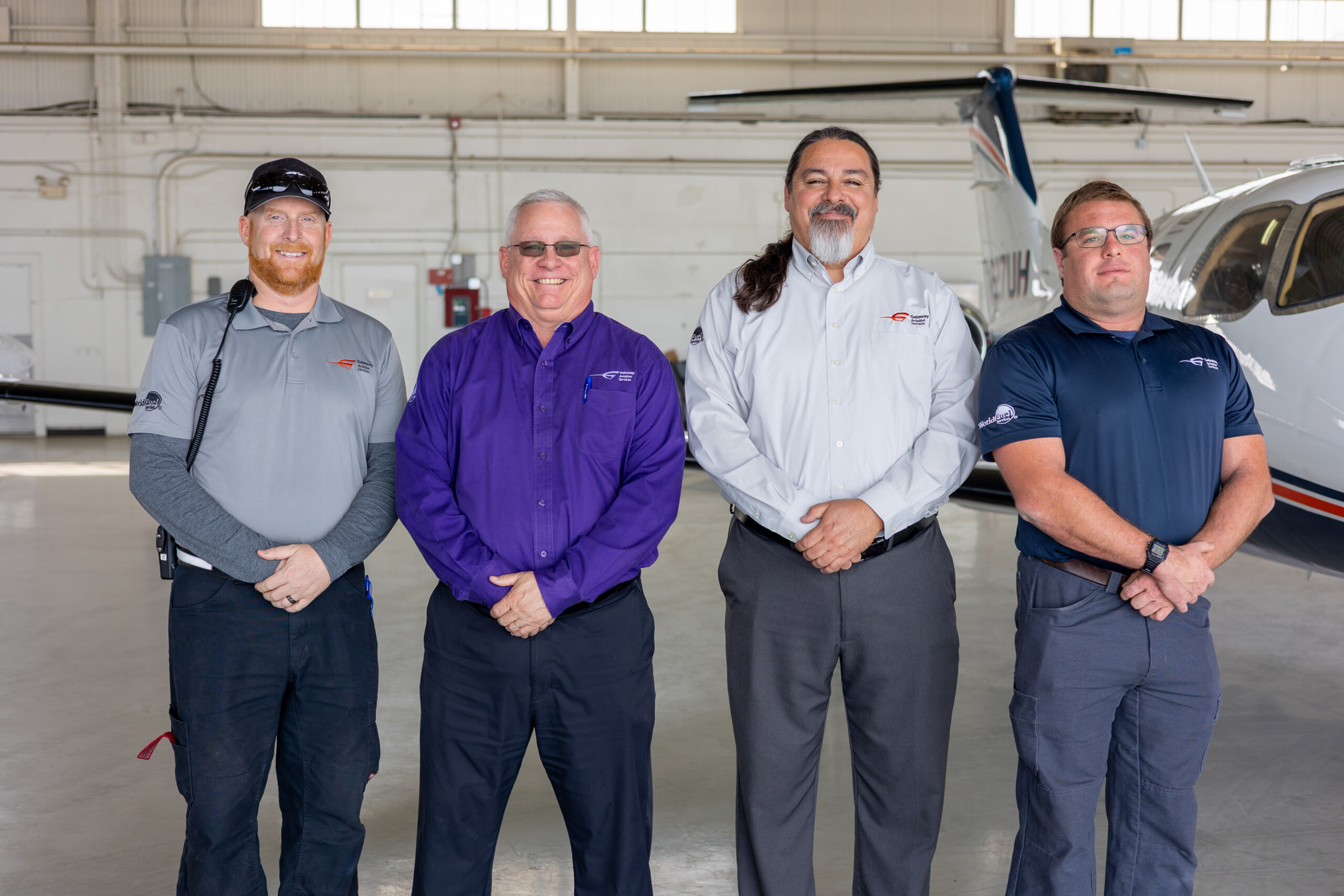Four Gateway Aviation Services staff members in a hangar