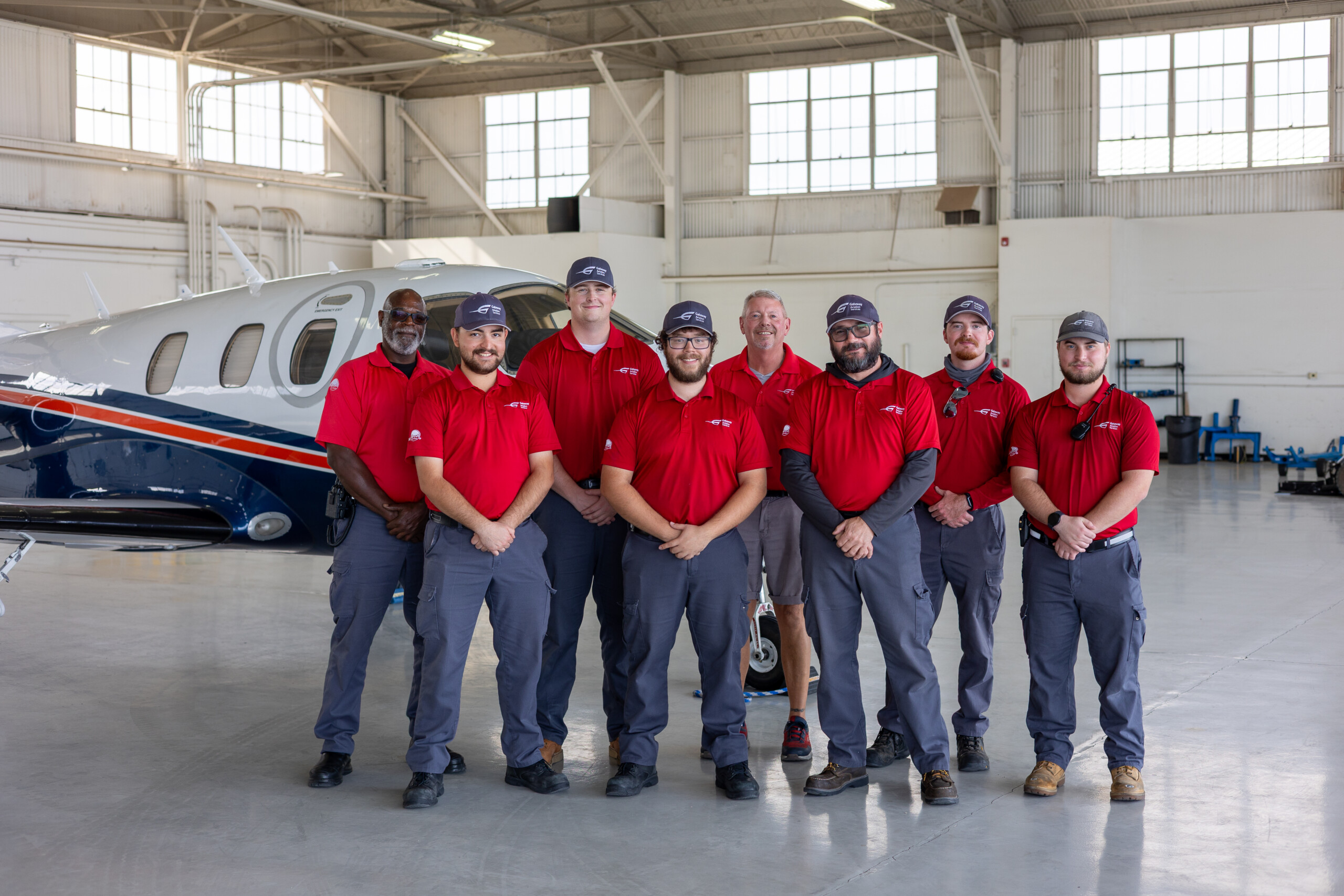 Gateway Aviation Services line crew posing in front of a jet in a hangar