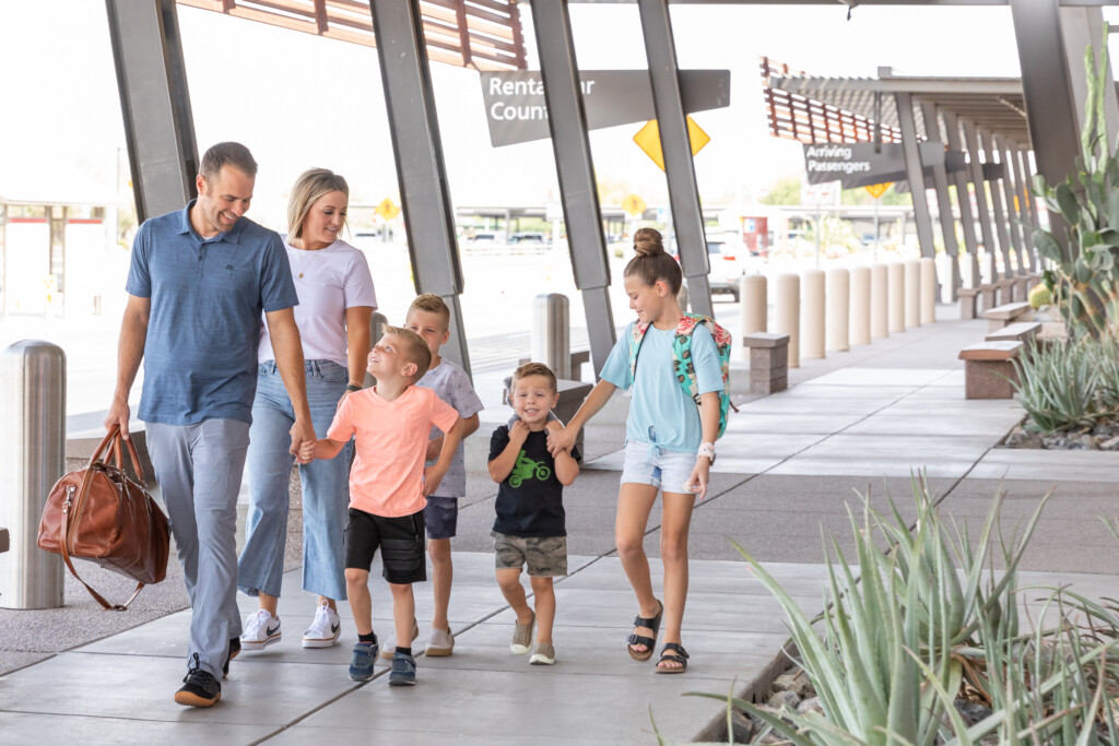 Family of five with luggage walking to the terminal