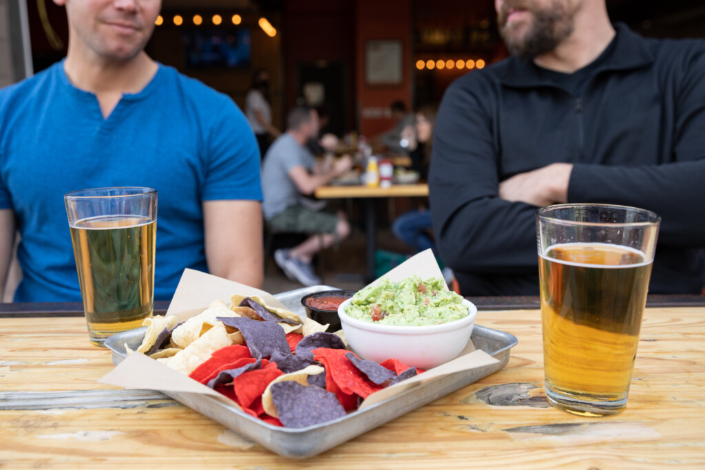 Tray of nachos and two beers on a restaurant table