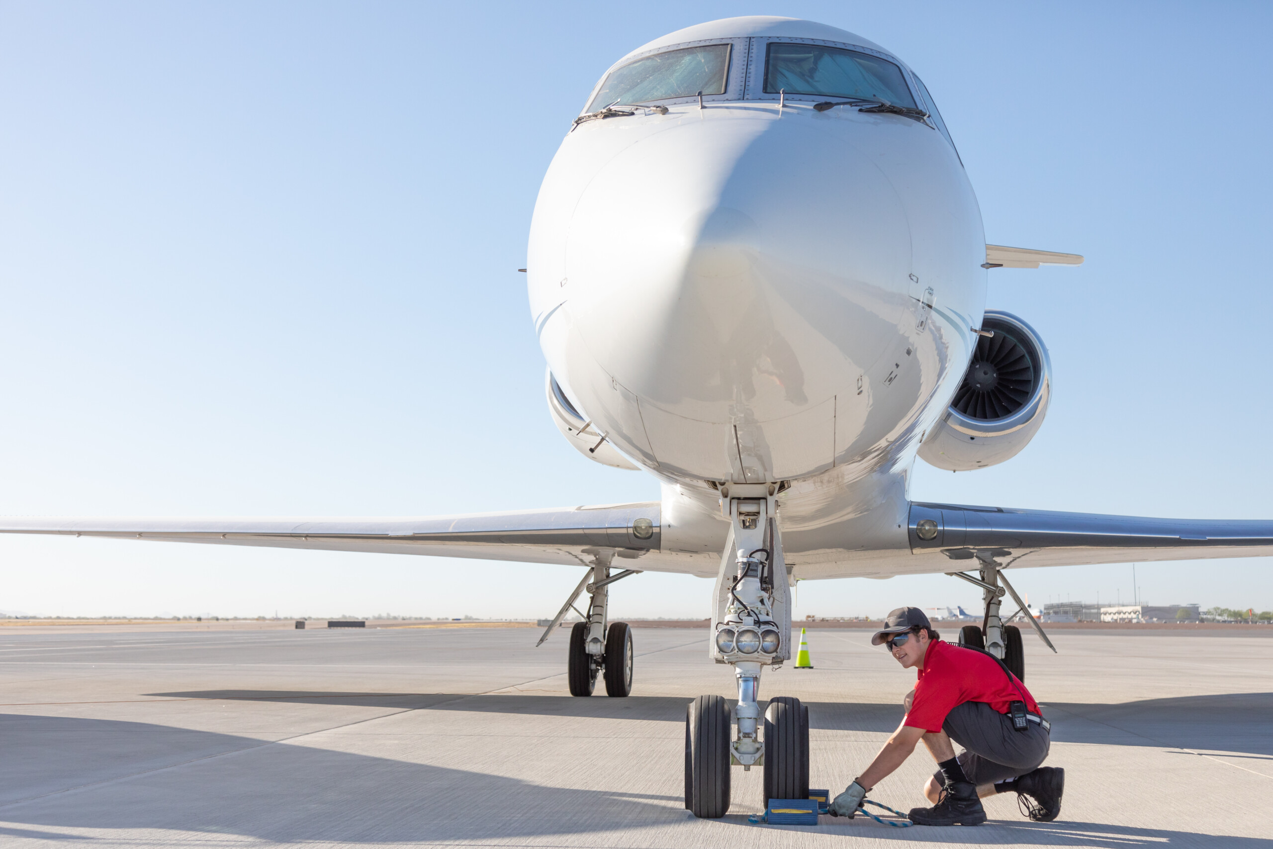 Technician inspecting the nose gear of a business jet