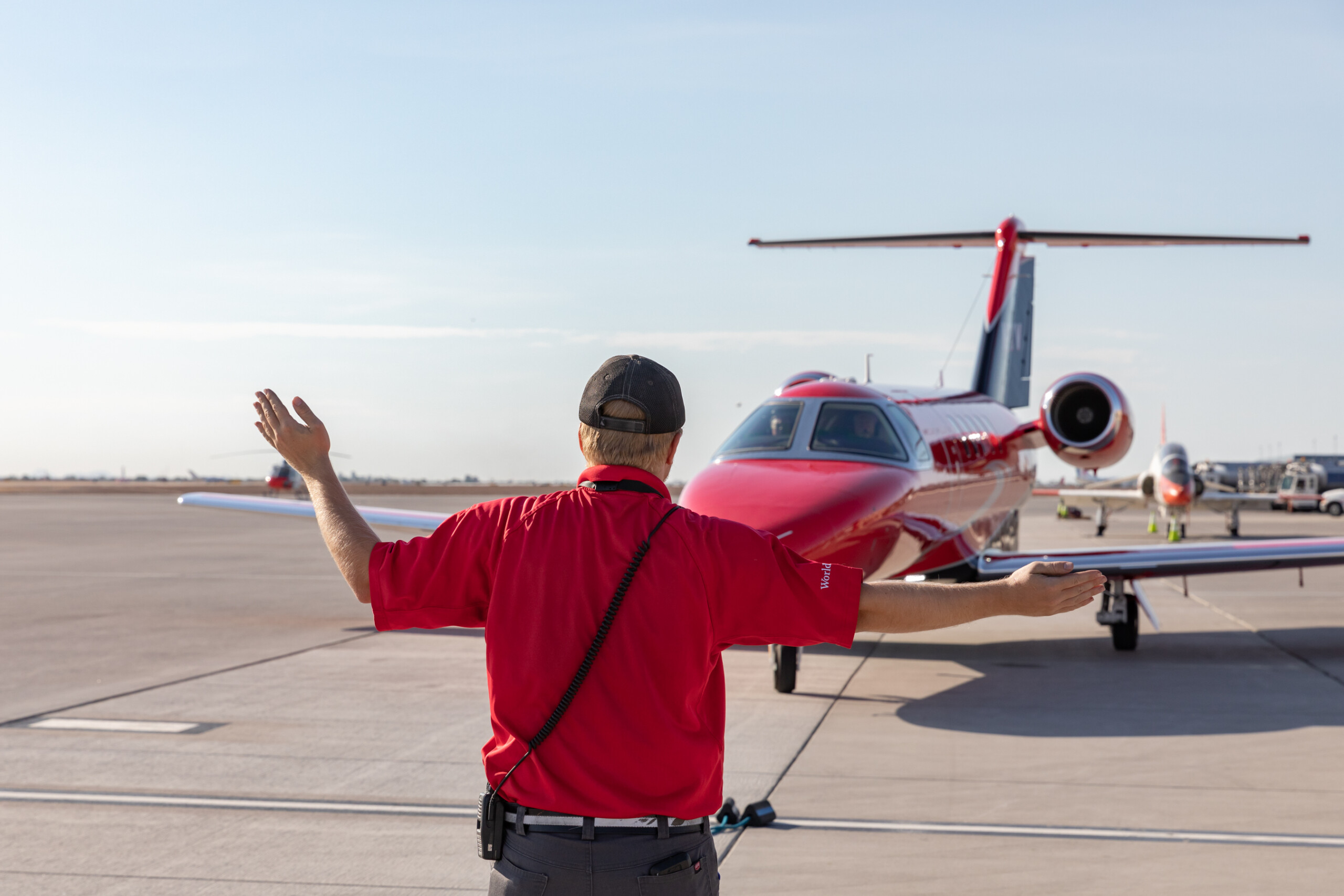 Ground crew member marshalling a private jet on the ramp