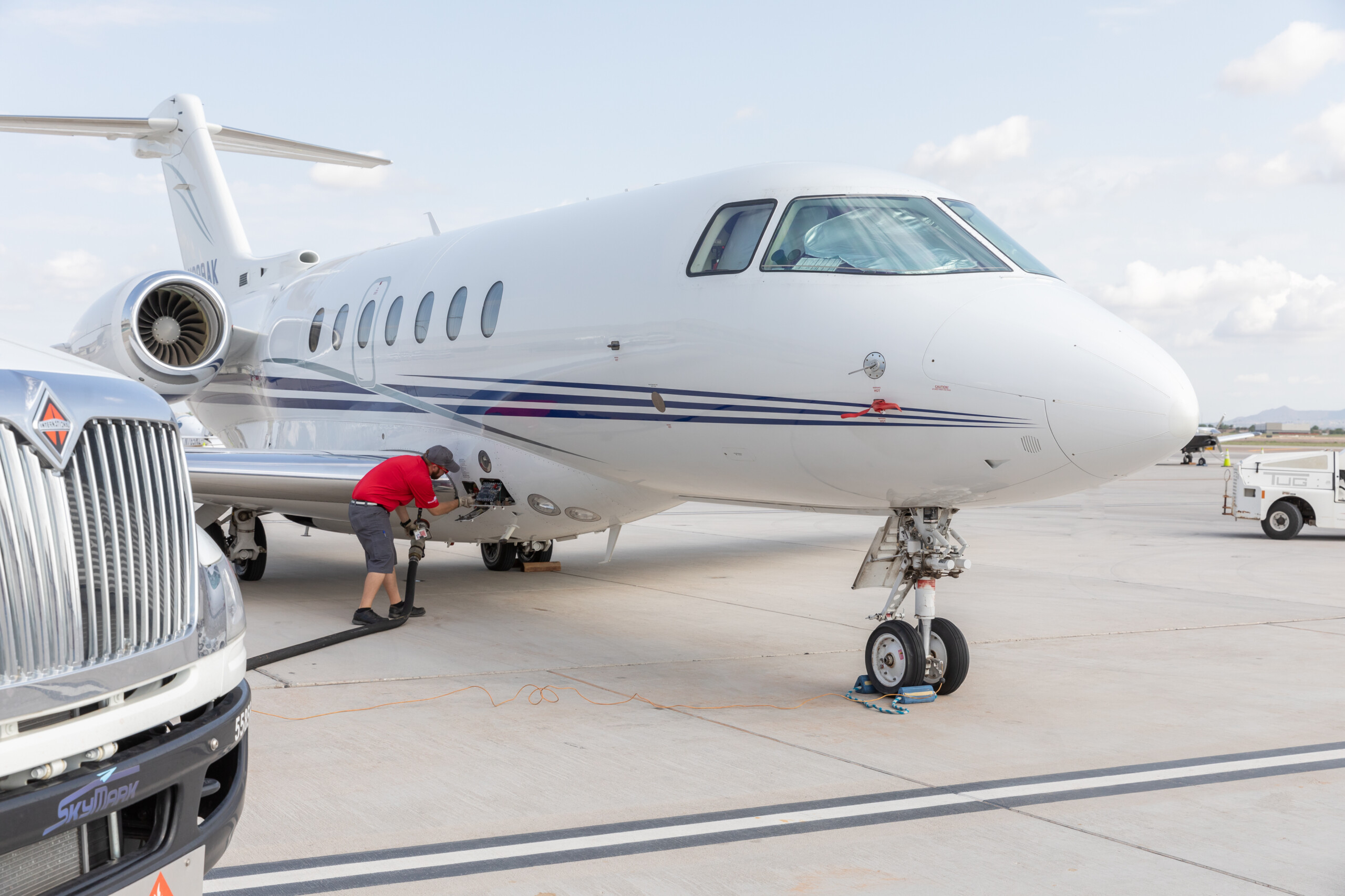 Business jet being refueled beside a fuel truck