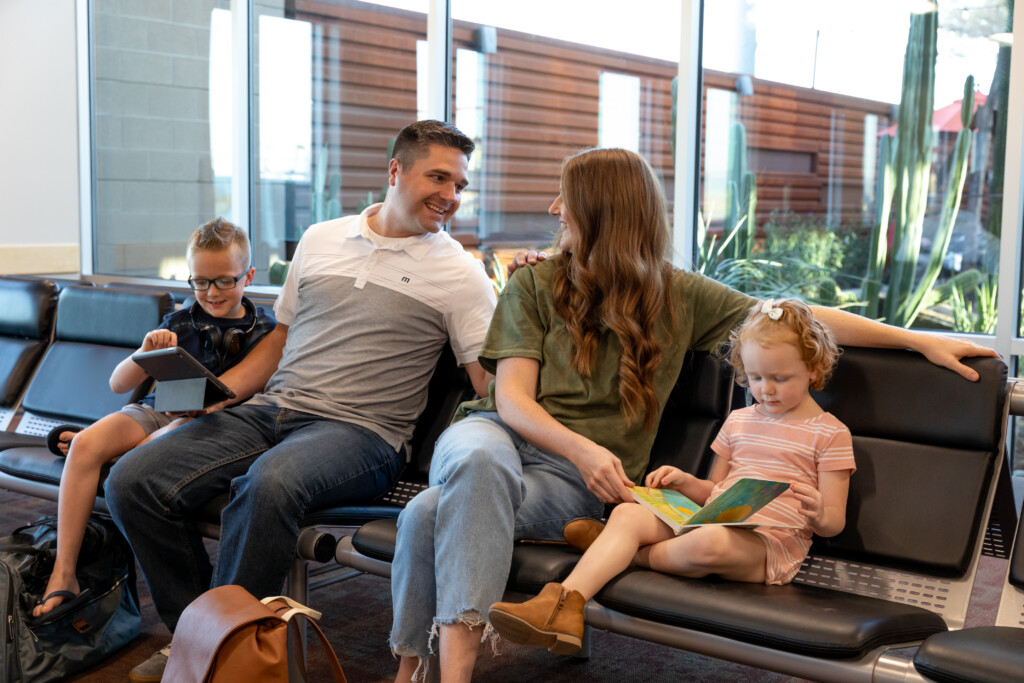 Family with young children reading together in gate seating