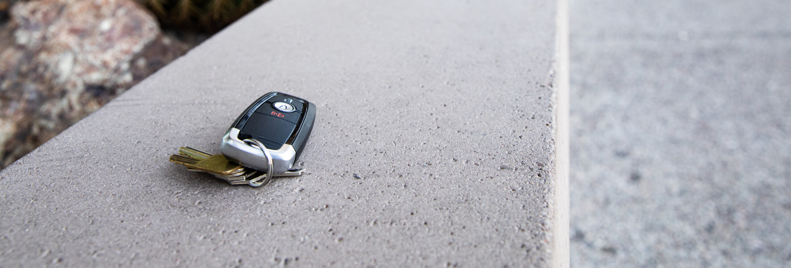 Car key fob left on a concrete ledge