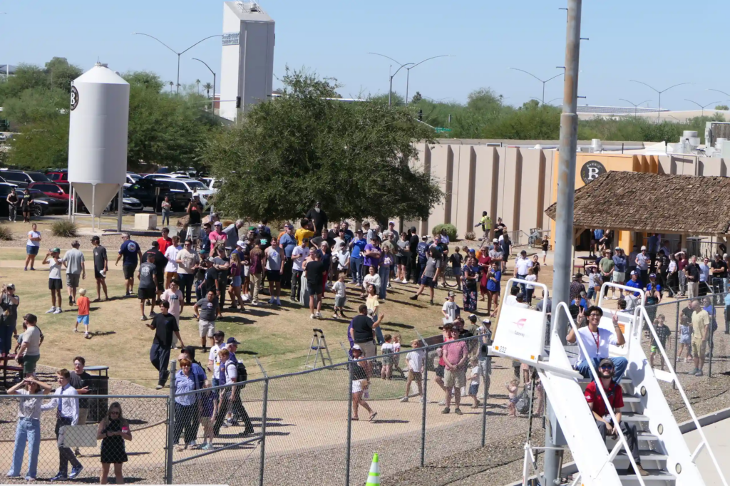 Crowd gathered on the airport grounds for a community event, seen from above
