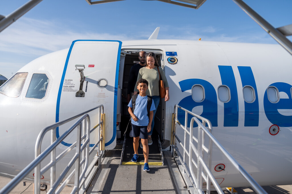 Father and son stepping off an Allegiant aircraft by airstairs