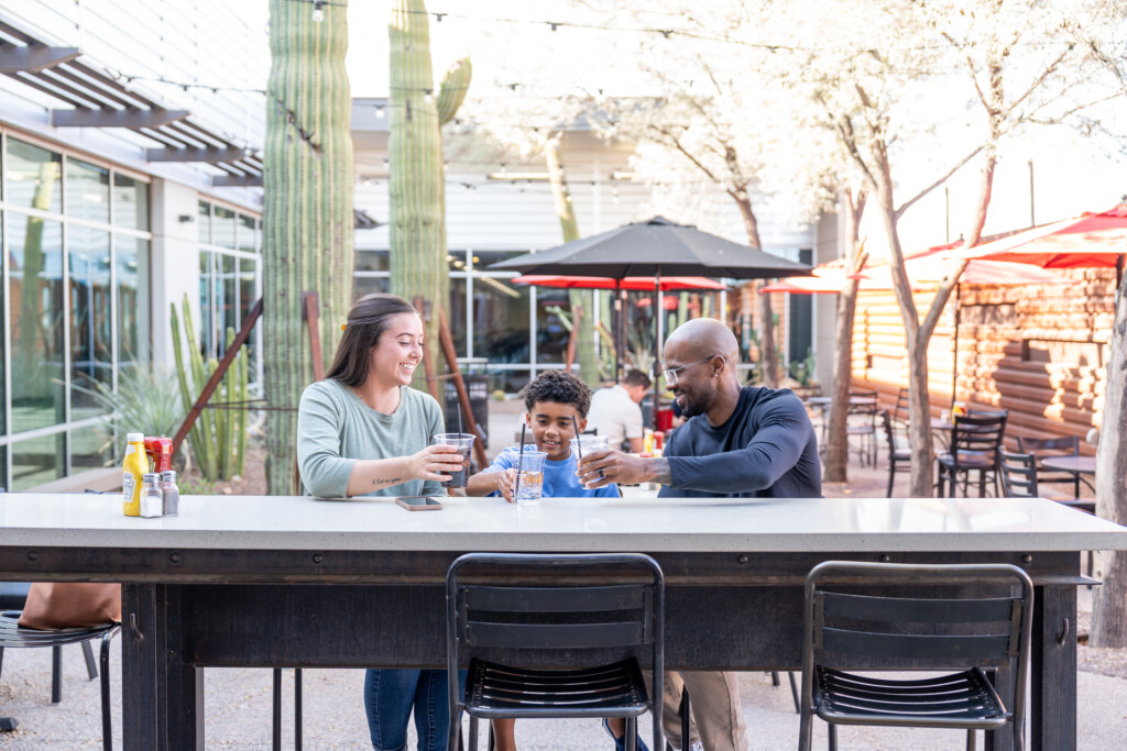 Family sharing a meal at an outdoor courtyard table