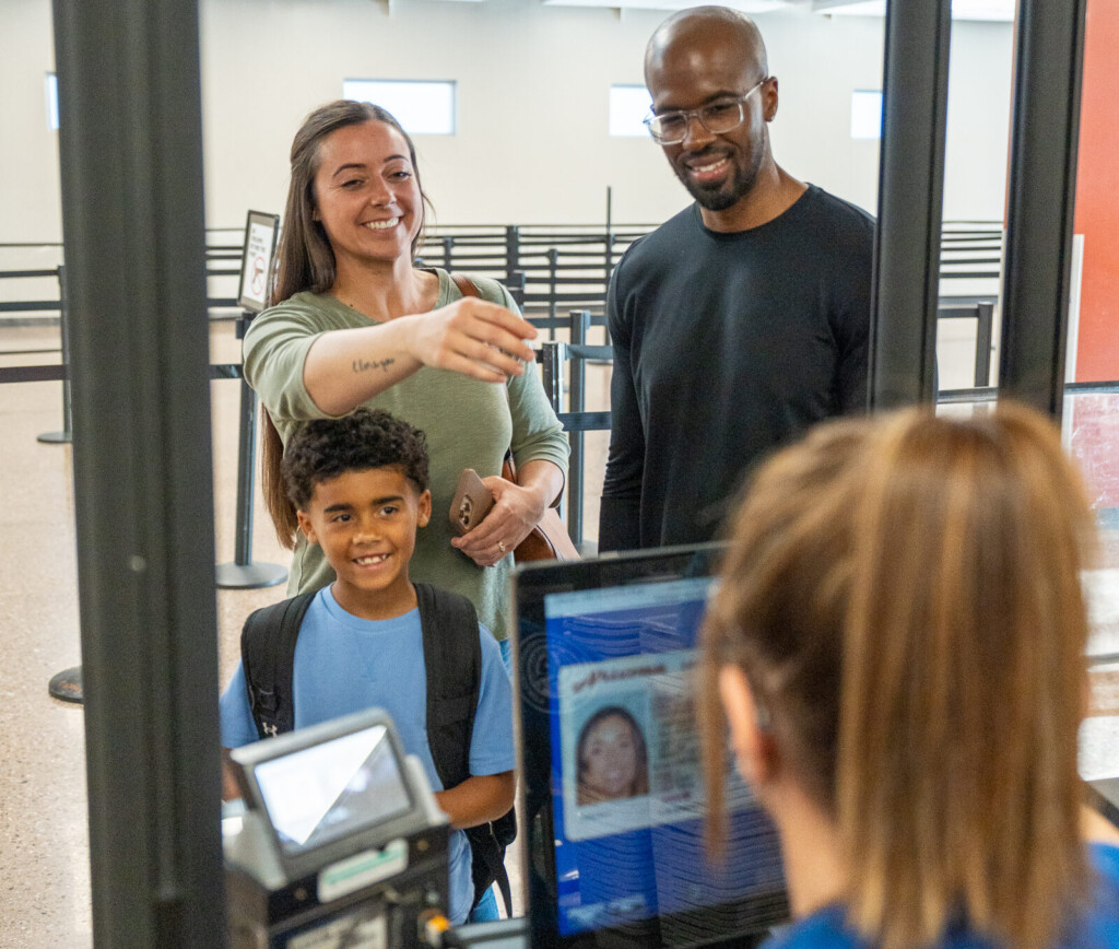 Family at the security checkpoint document-check station with a TSA officer