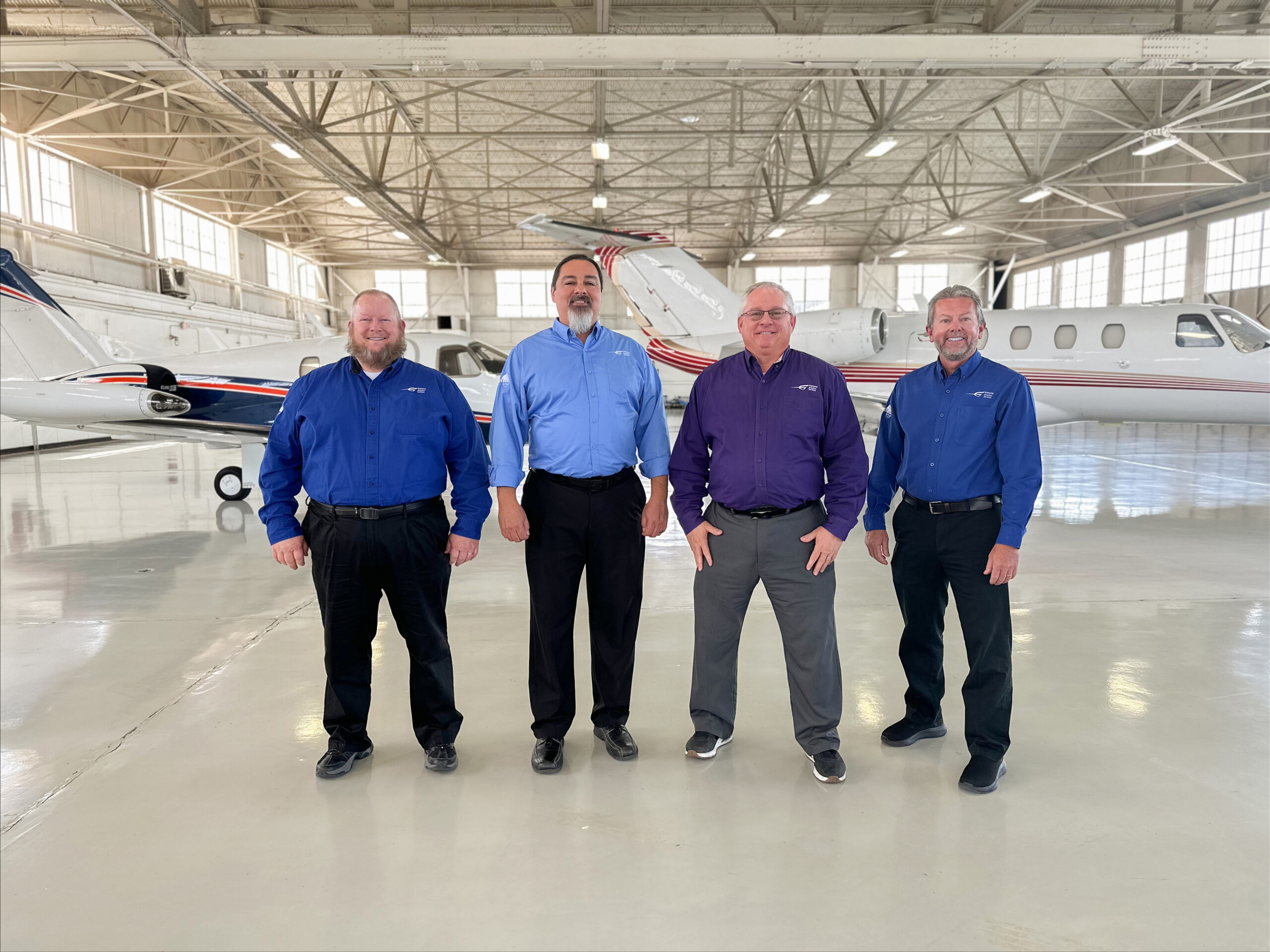 Four Gateway Aviation Services team members in a hangar