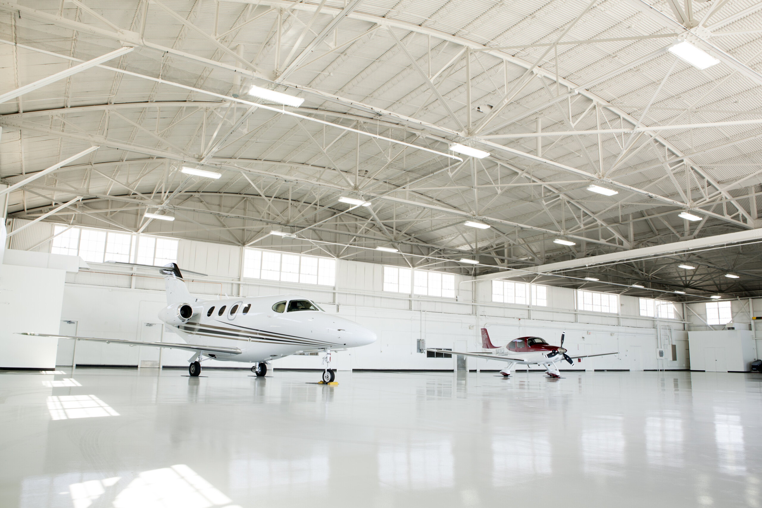 Private jets parked inside a large hangar