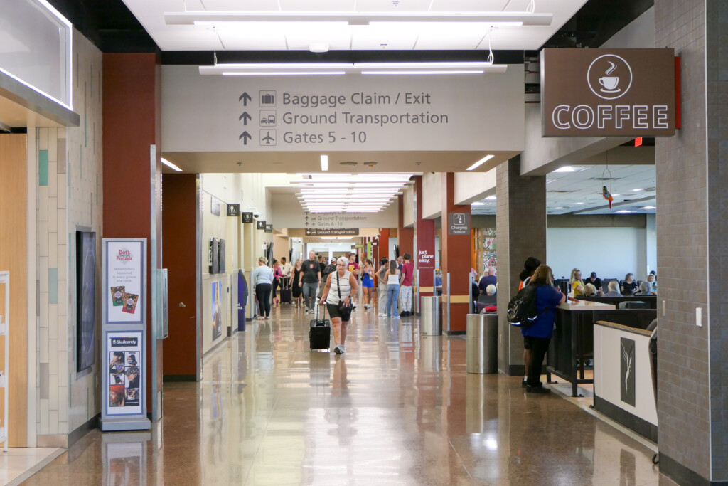 Concourse corridor with signs for baggage claim, ground transportation and the coffee shop