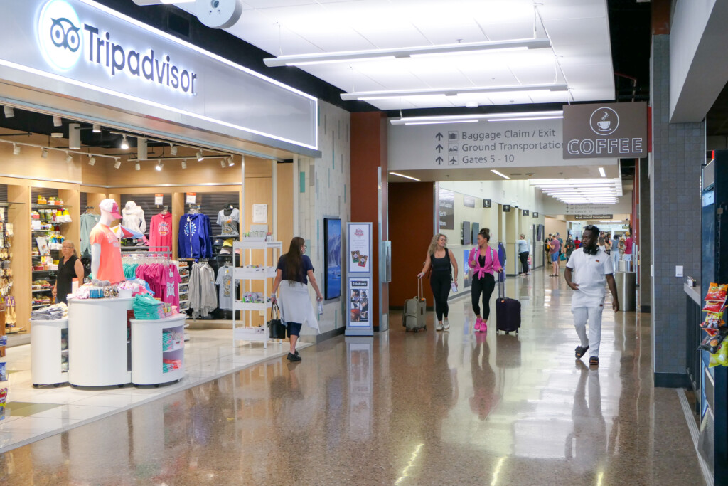 Travelers walking past the Tripadvisor store in the concourse