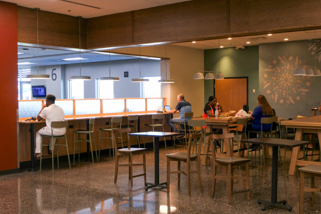 Dining area with tables and chairs near a gate