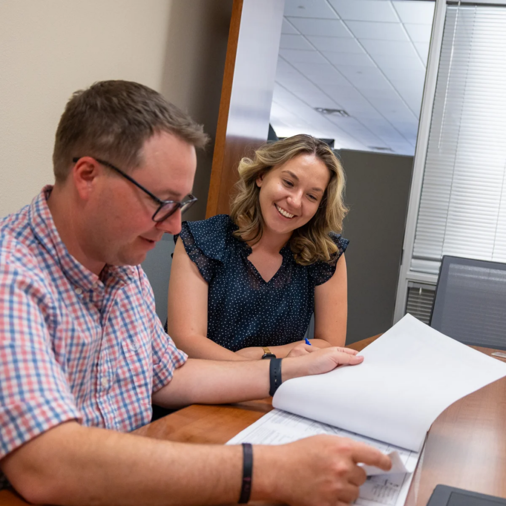 Two coworkers reviewing a document together at a desk