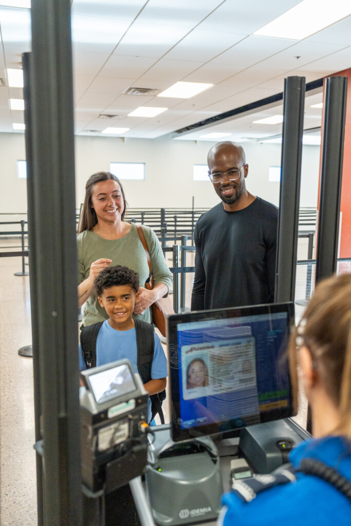 Family at the security checkpoint document-check station with a TSA officer