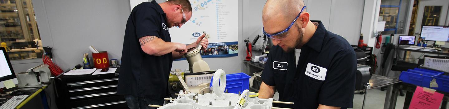 Two maintenance technicians working together at a workbench