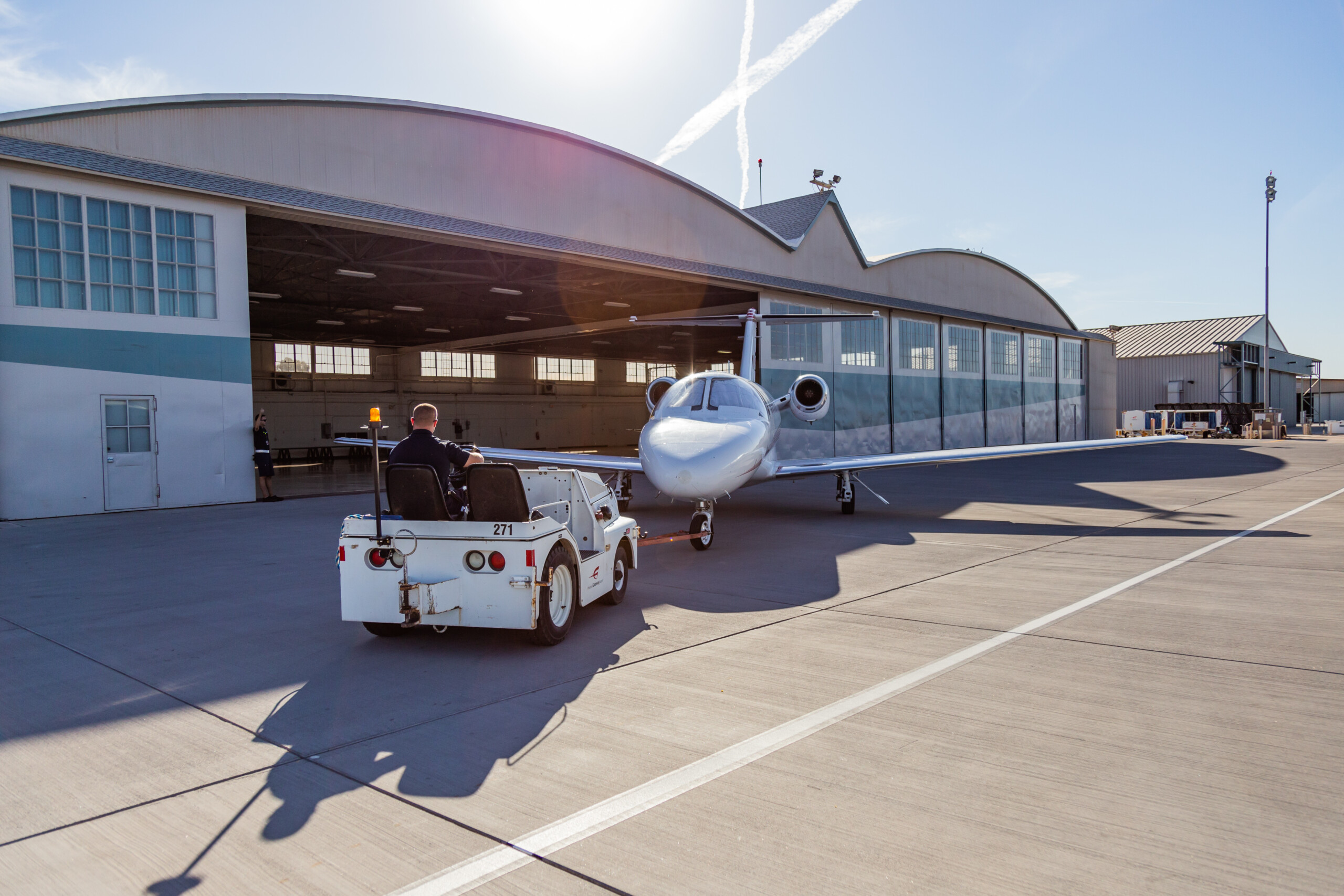 Tug pulling a business jet out of a hangar