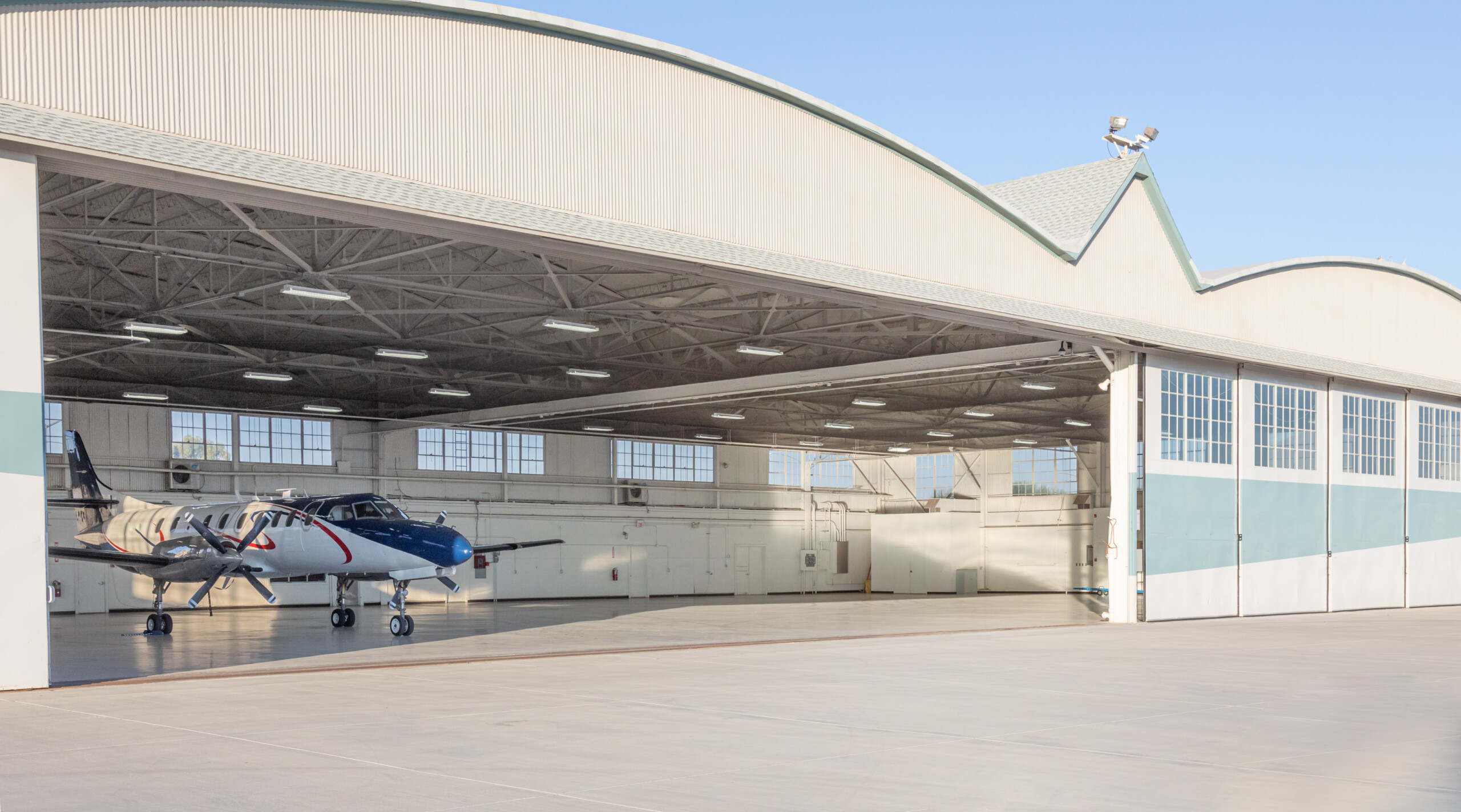 Aircraft hangar with its door open and a small plane inside