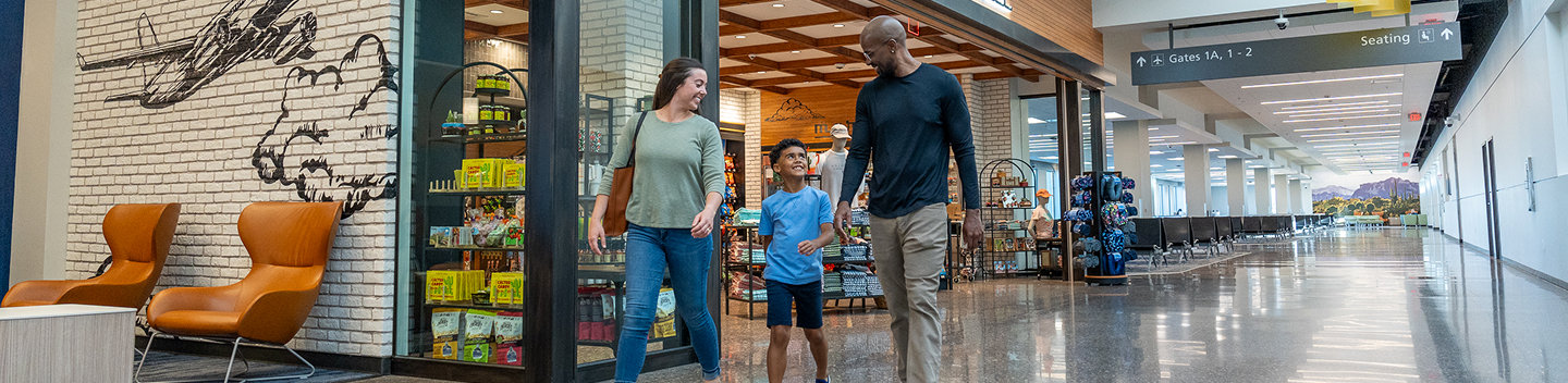 Family walking through the terminal shopping area past the First Jet Market