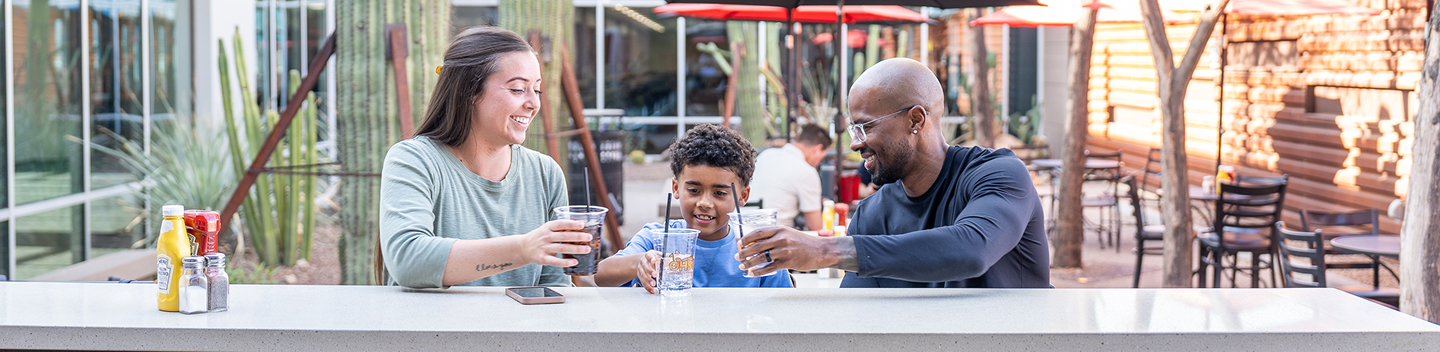 Family enjoying drinks at an outdoor table in the terminal courtyard