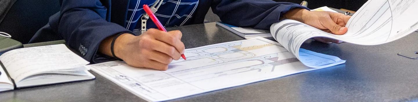 Person filling out paperwork at a counter