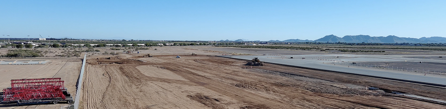 Aerial view of land being graded for development beside the airport