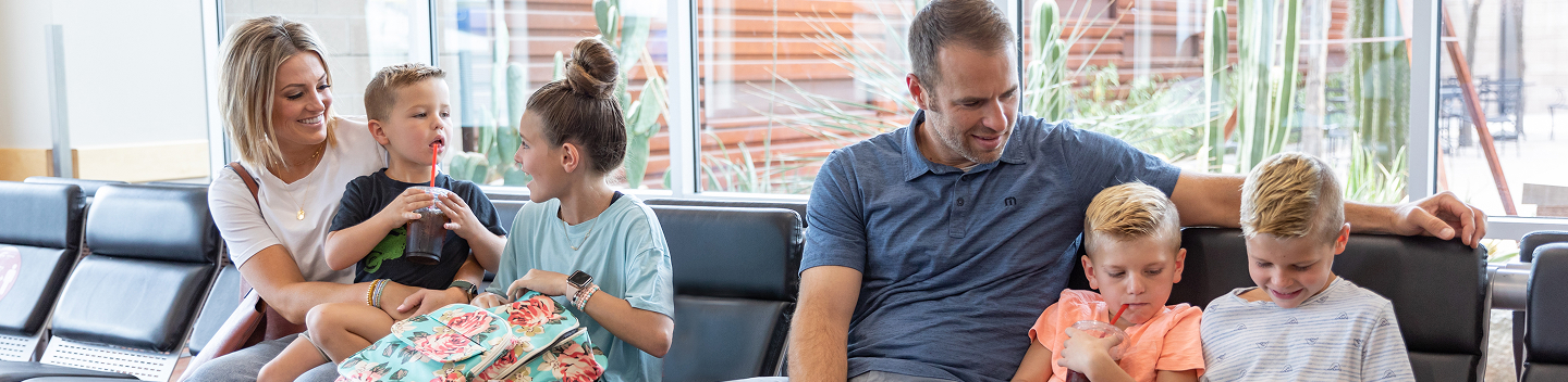 Two families relaxing in the gate seating area